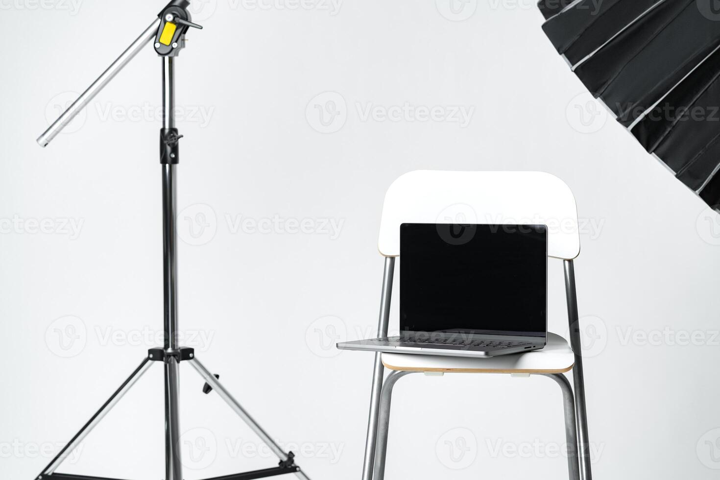 Laptop with black screen and photography equipment in photostudio photo