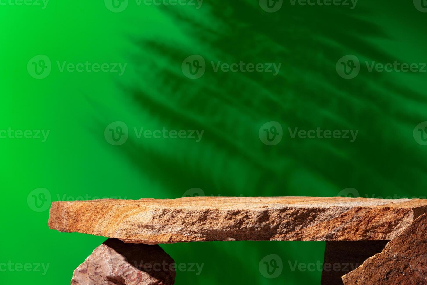 Stone display for product against green background photo