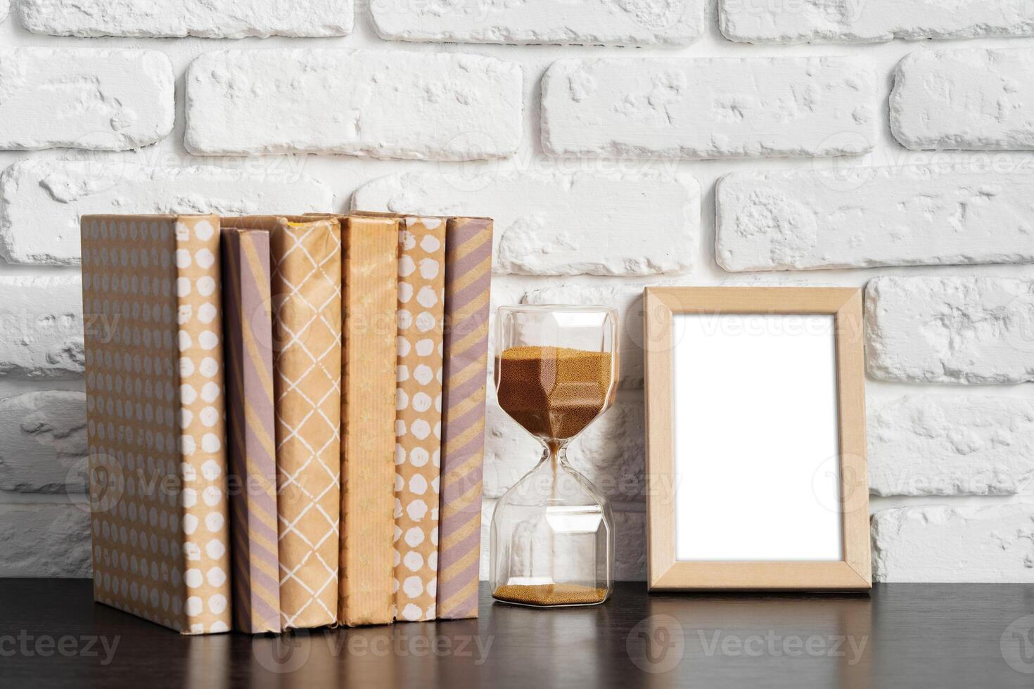 Books with picture frame on wooden table photo