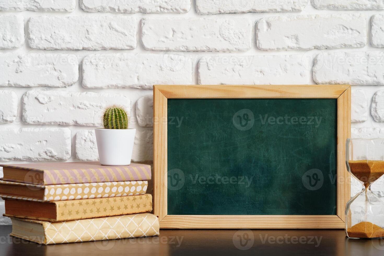 Books with picture frame on wooden table photo
