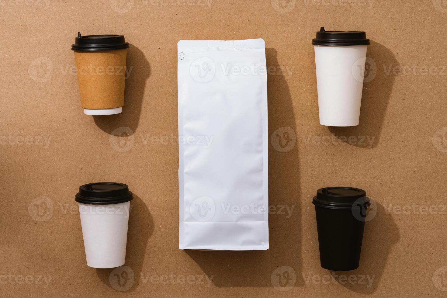 Blank coffee package with copy space and takeout cups on beige background photo