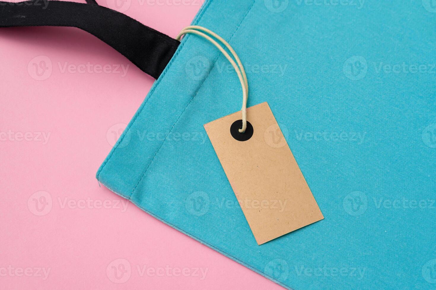 Textile shopping bag on pink paper background flat lay photo