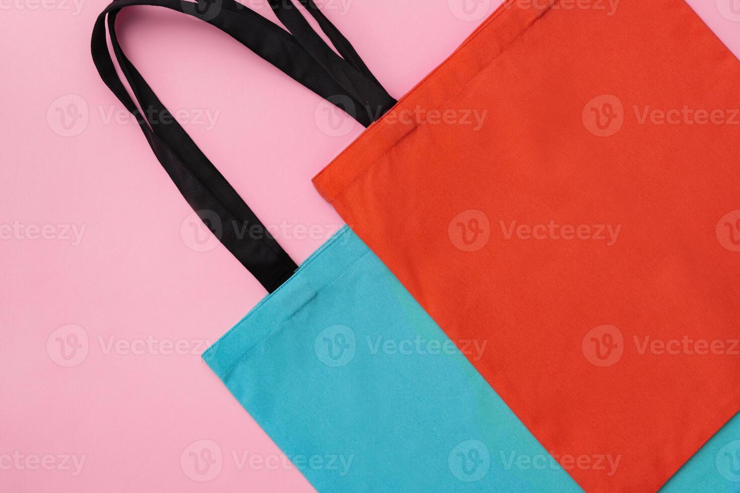 Textile shopping bag on pink paper background flat lay photo