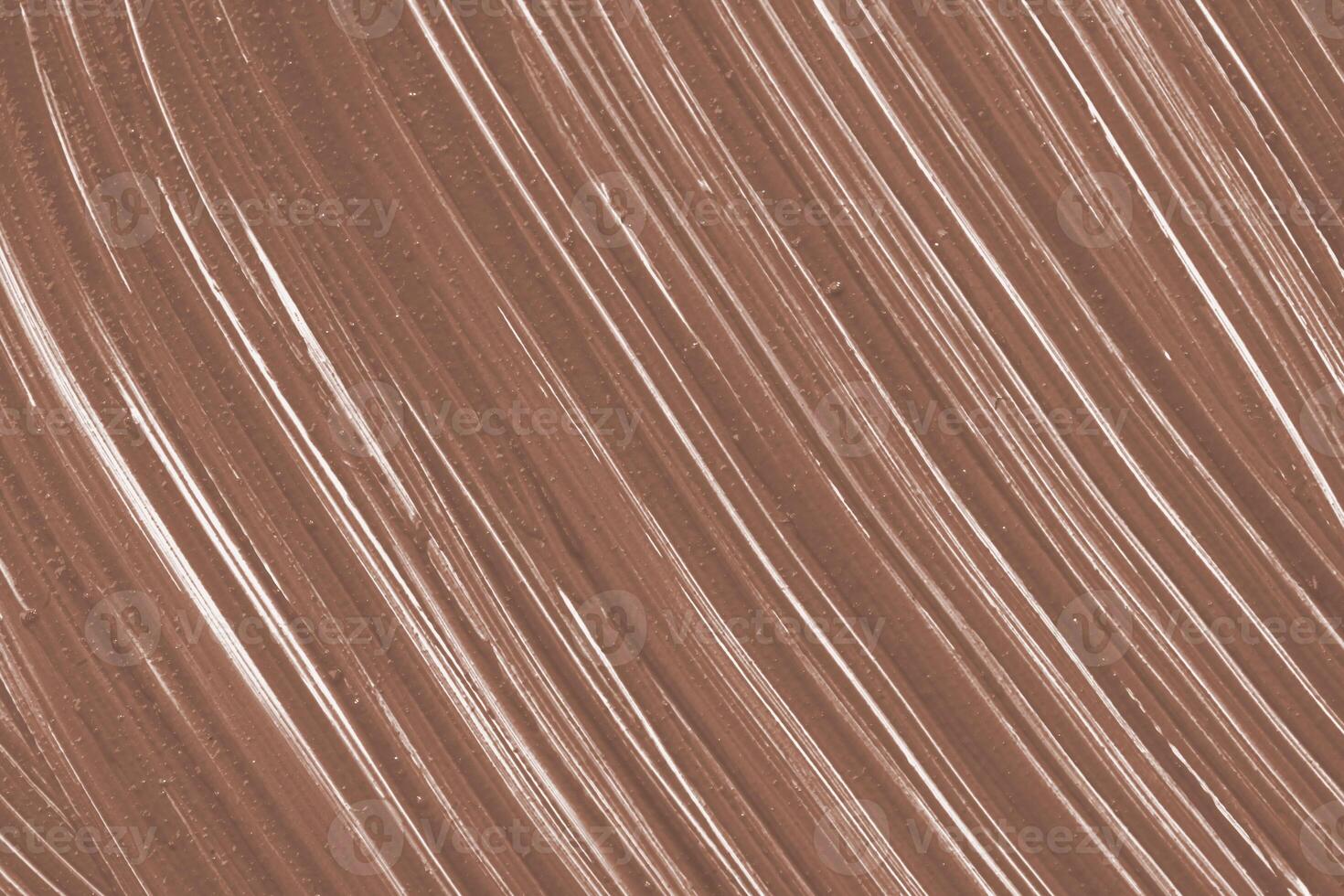 Swirling patterns of brown and white create an artistic texture on a smooth, soft surface during daylight photo