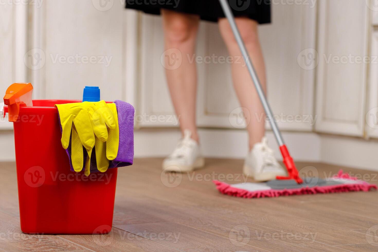 Woman washing floor with mop in kitchen photo