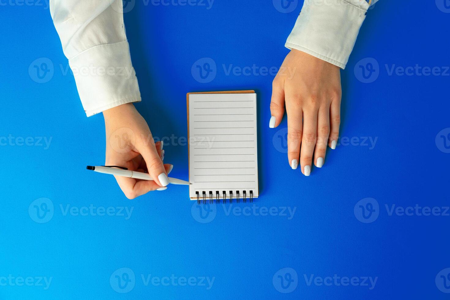 To do list. Top view of female hands writing in notebook photo