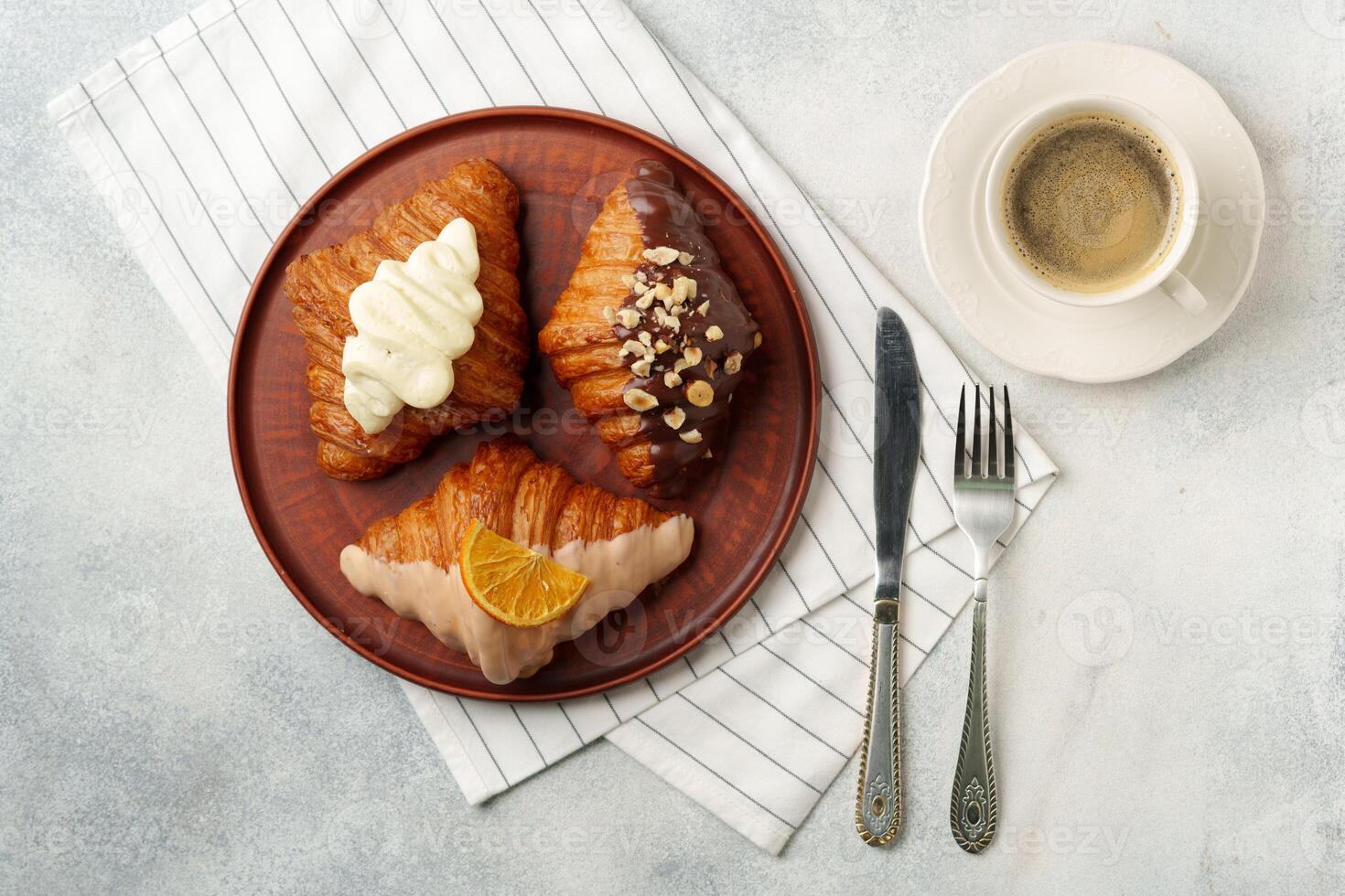 Glazed croissants on clay plate on table photo