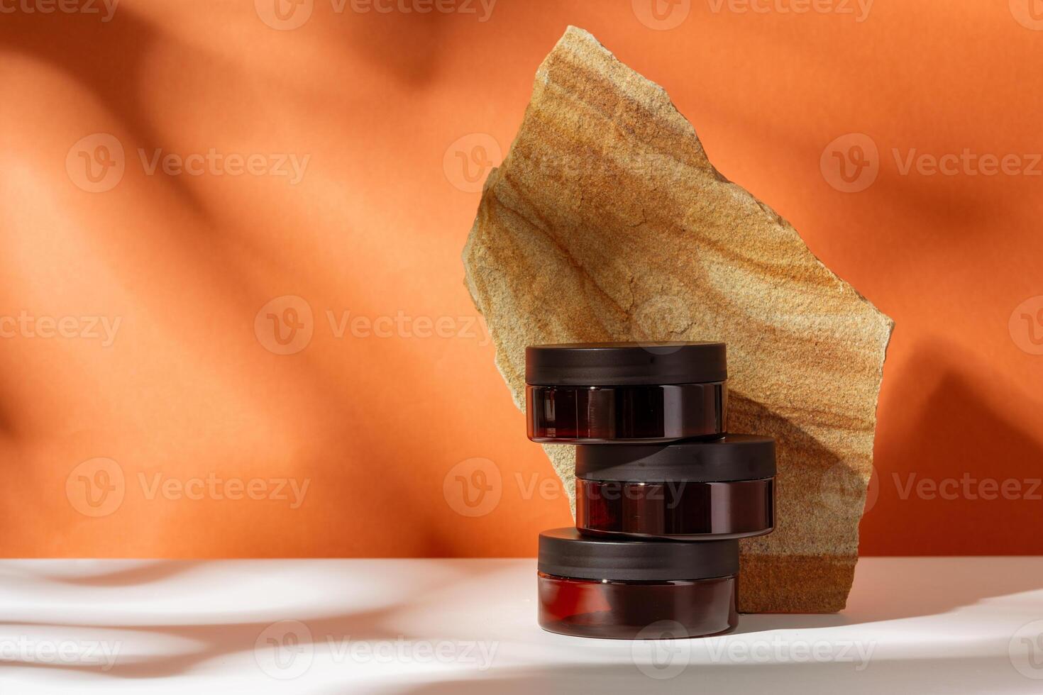 Cosmetic product jar in composition with granite stones and shadow photo