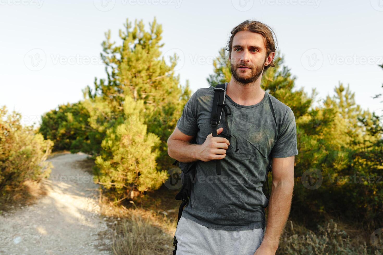 Portrait of hiker man with backpack trekking in the mountains photo