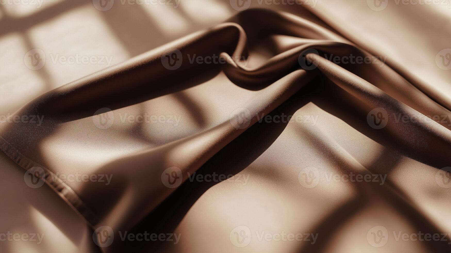 Soft brown fabric draped elegantly with light and shadow patterns in a warm indoor setting photo
