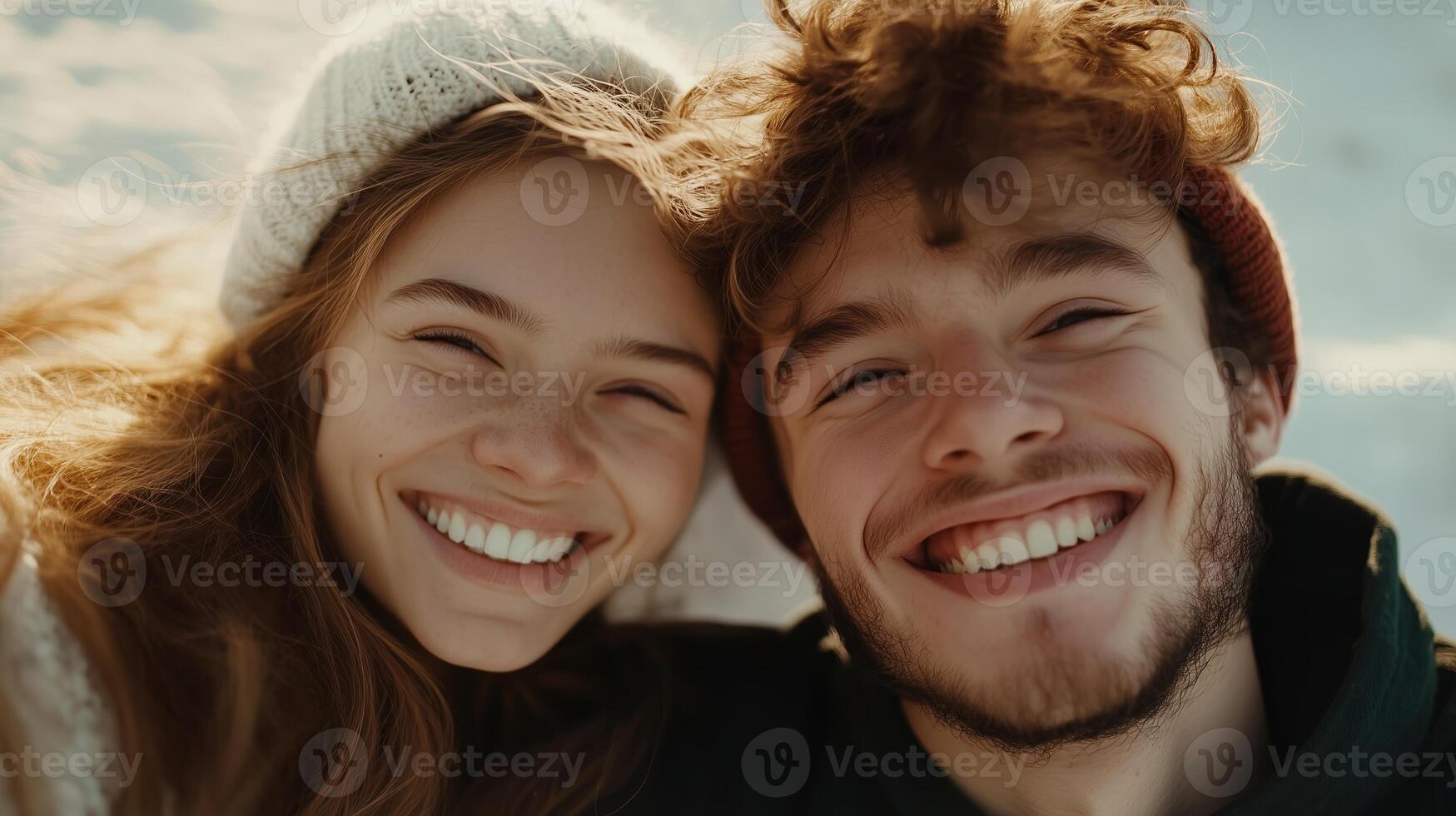 Joyful young couple smiling warmly while enjoying a sunny winter day outdoors in a snowy landscape photo