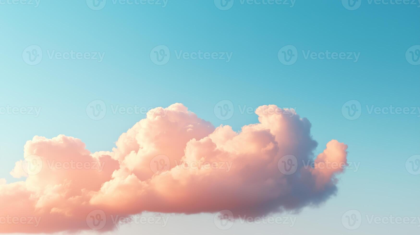 Soft pink clouds floating in a clear blue sky during a tranquil afternoon photo