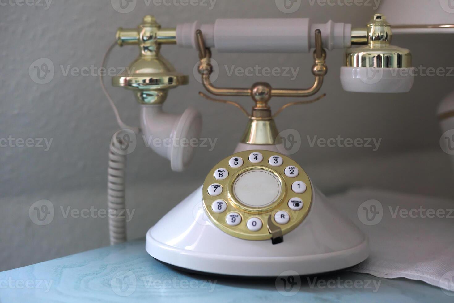 Vintage phone with a golden dial plate photo