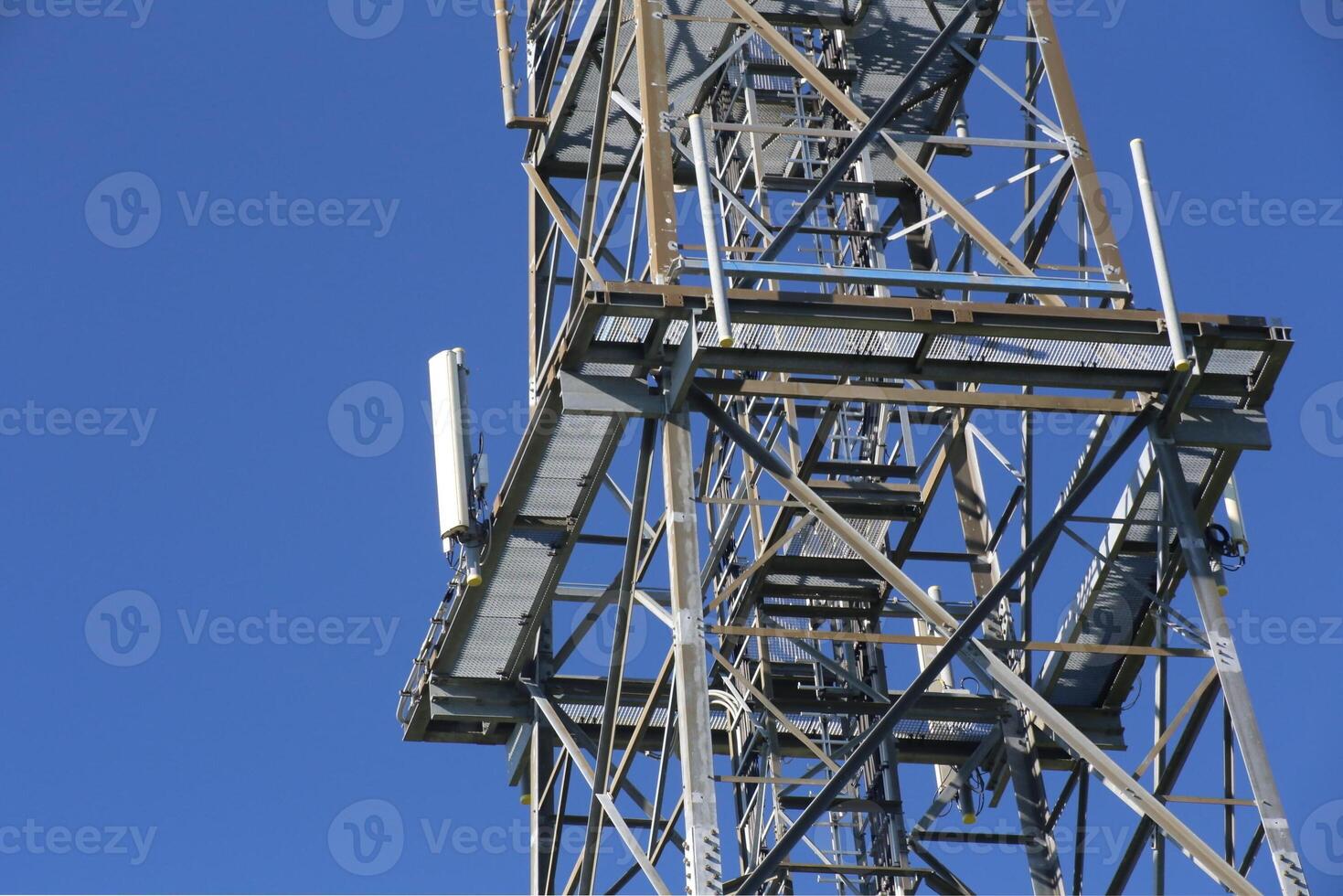 Metal frame of telecommunications tower in front of a dark blue sky photo