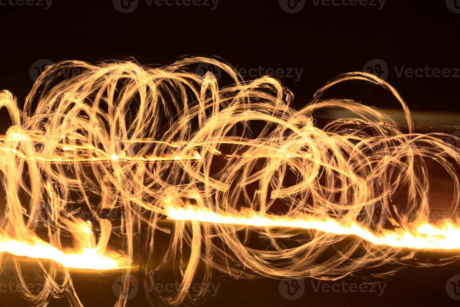 Long exposure shot of moving burning torches and fire photo