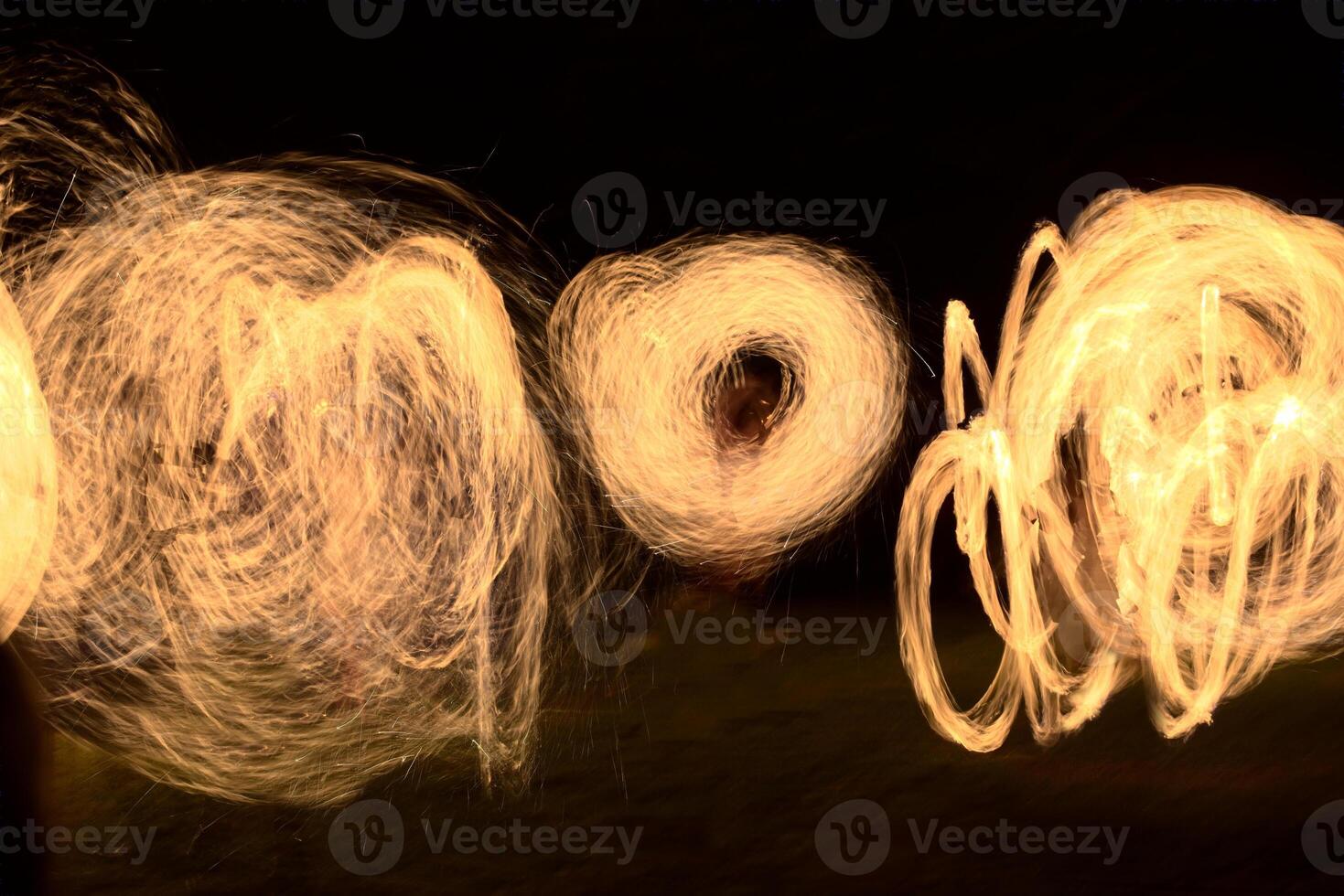 Long exposure shot of moving burning torches and fire photo