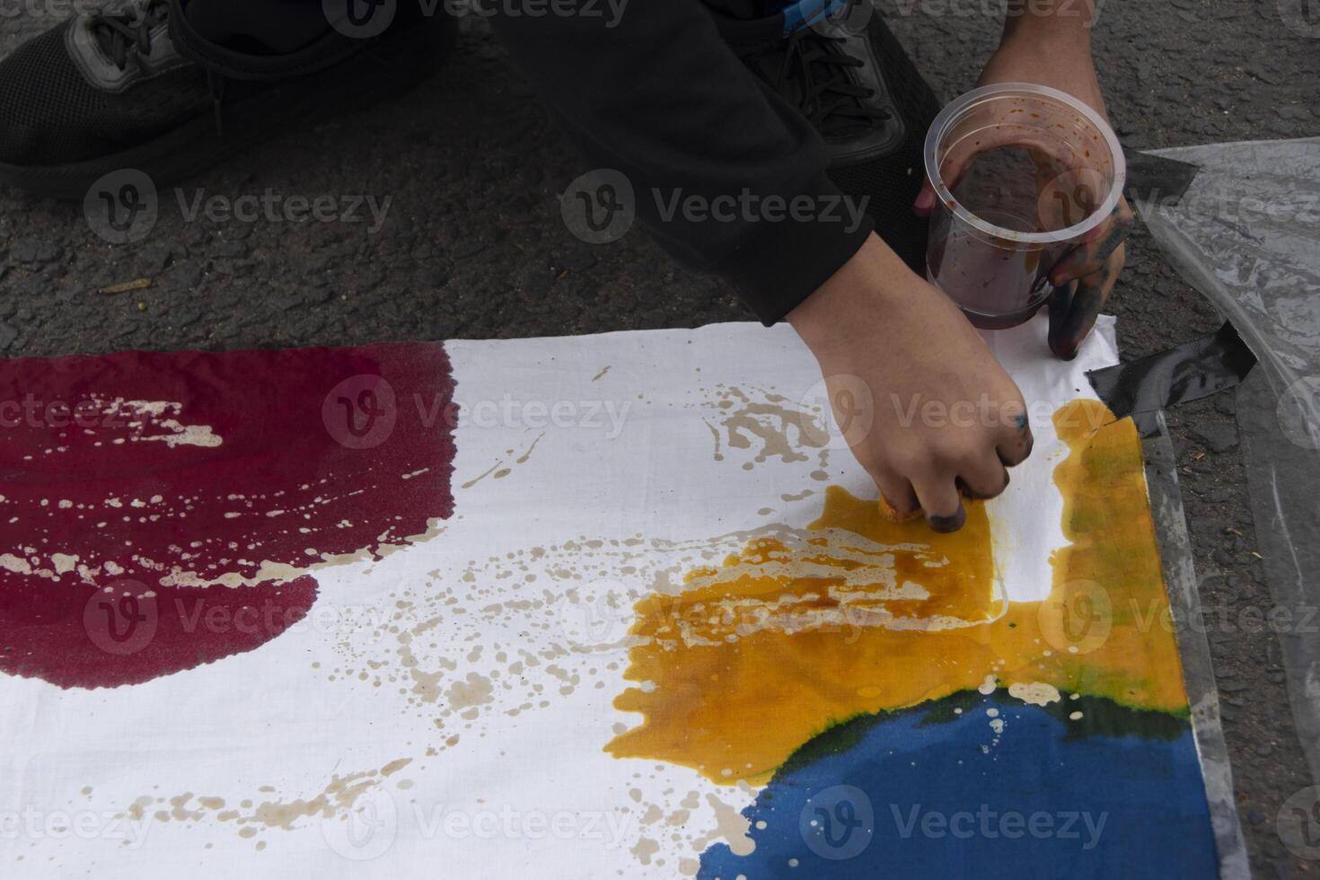 Someone was dyeing a piece of white cloth with textile dye. Students' creativity in making handicrafts using cloth as a medium. photo