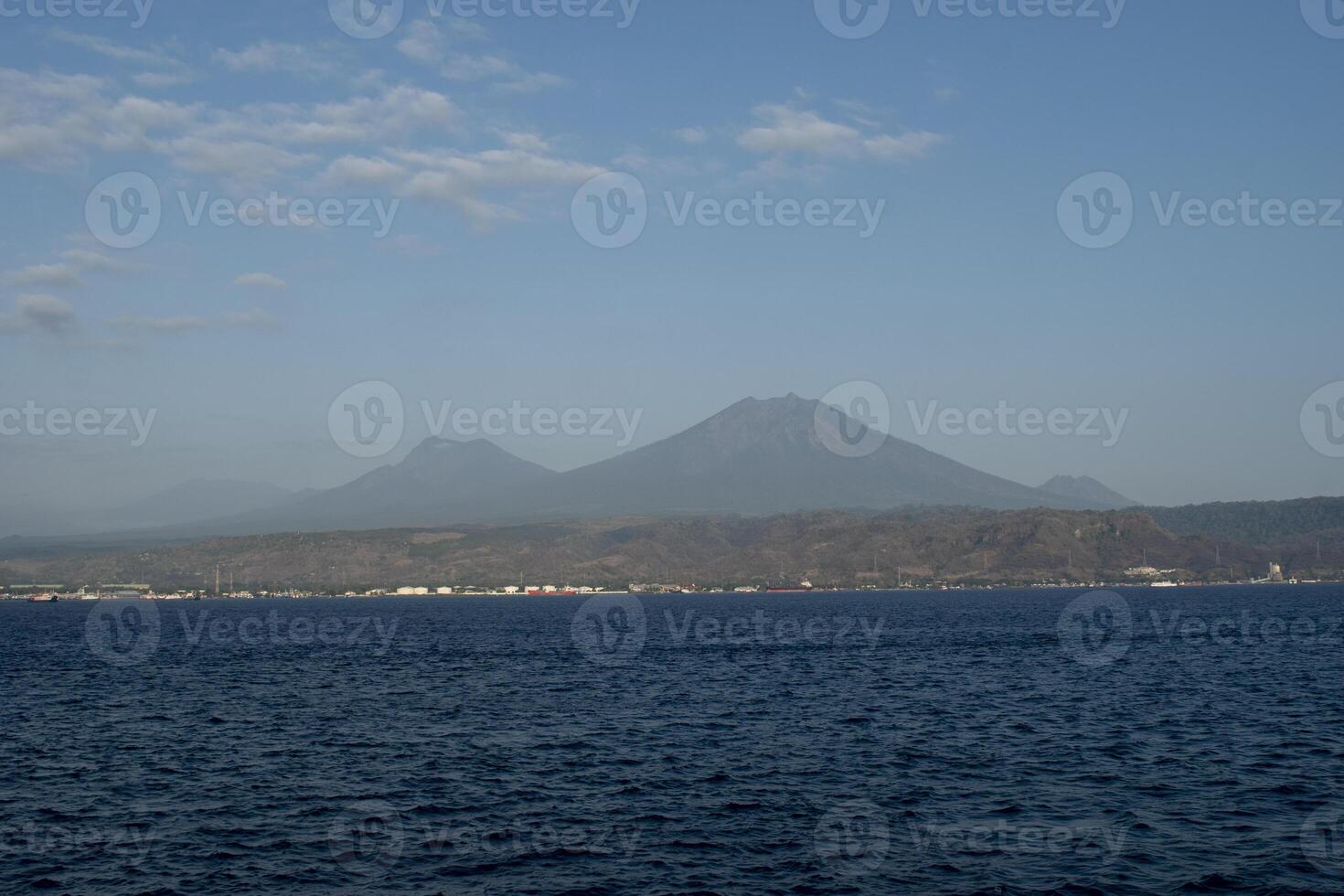 Mount Ijen seen from the Bali Strait with a blue sky. The Ijen volcano complex is a group of composite volcanoes located on the border between Banyuwangi and Bondowoso Regency of East Java, Indonesia. photo