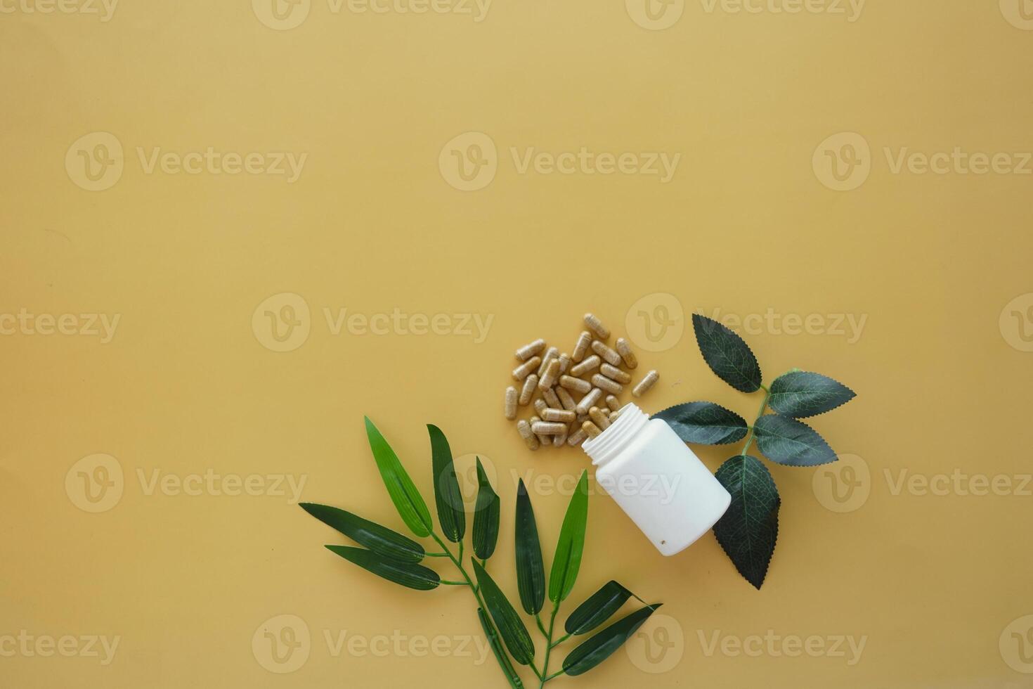 Natural Dietary Supplements Featuring Green Leaves Set on a Yellow Background photo