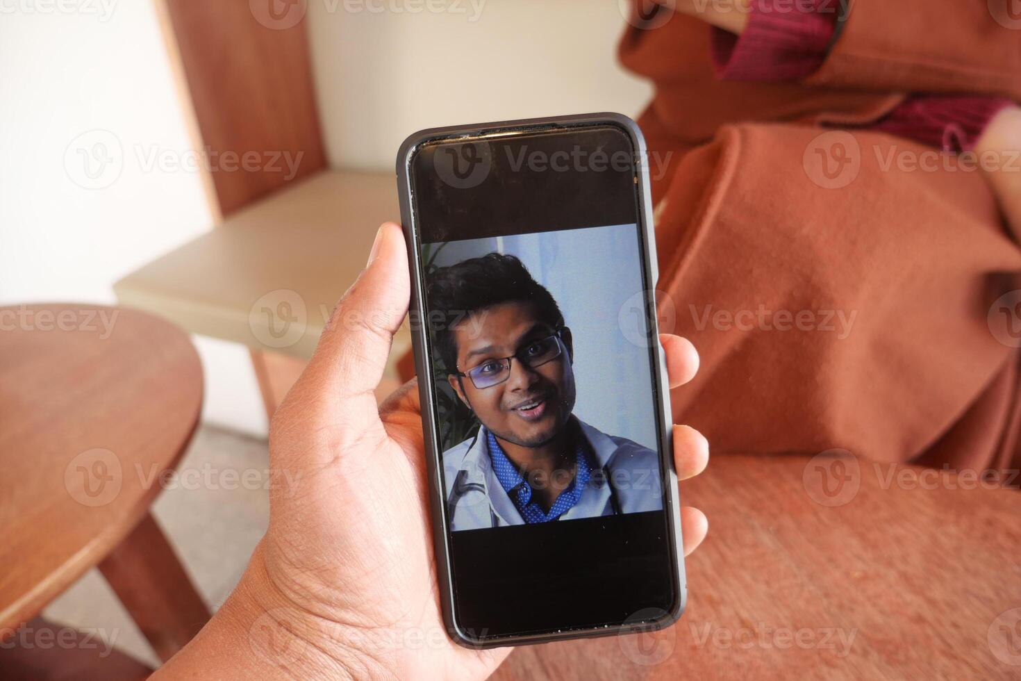 women taking online consultation with doctor on smart phone photo