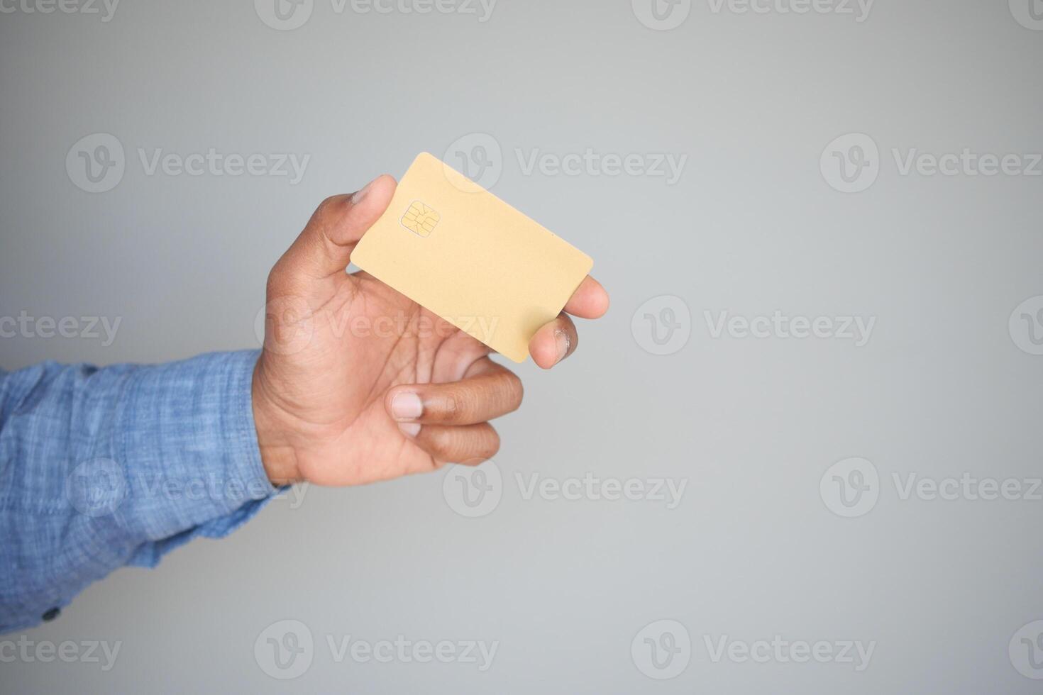 Man in casual dress showing credit card photo