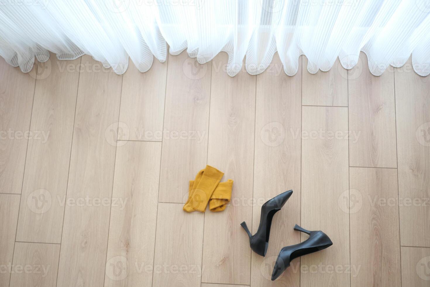 Elegant Black High Heels paired with a Yellow Scarf placed on Wooden Floor photo