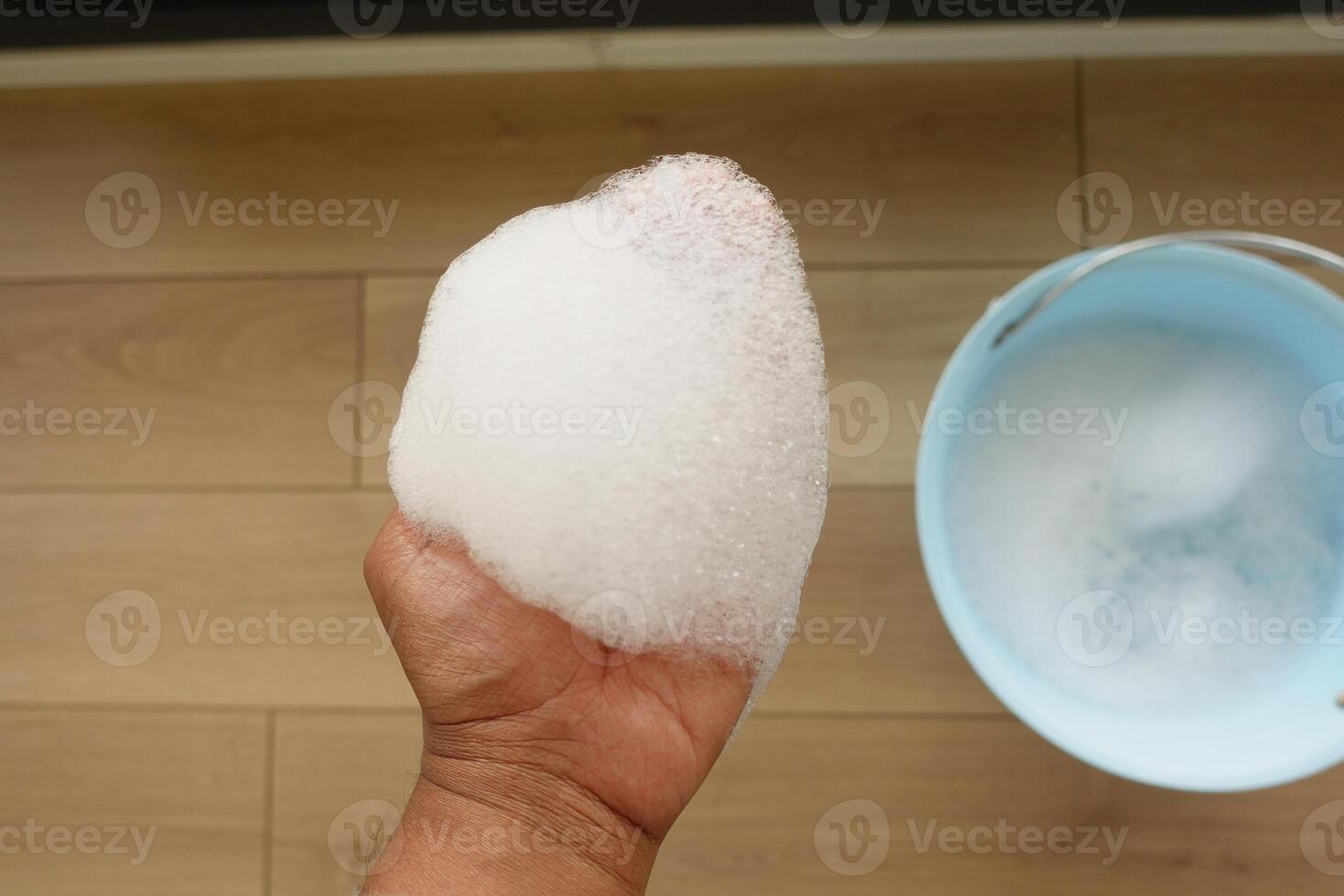 A small amount of soapy foam was collected in a bucket for household cleaning and hygiene photo