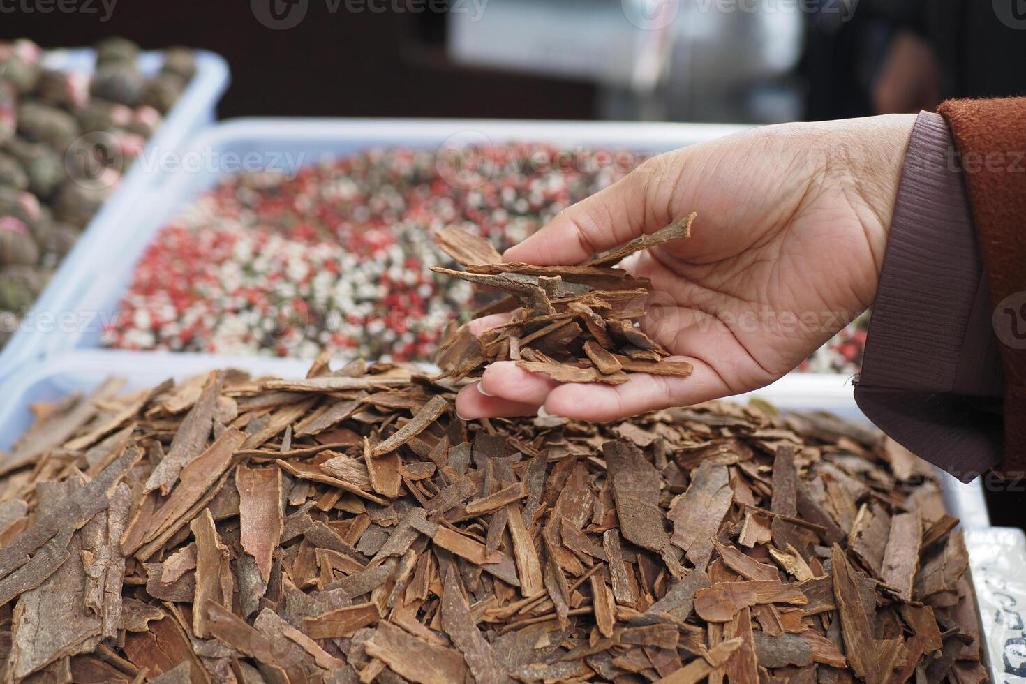 Hand Holding Various Natural Spices at a Vibrant Market Stall photo