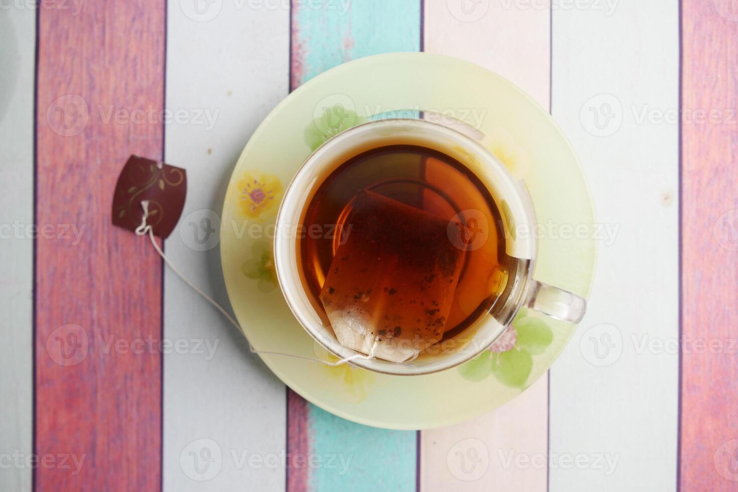 A Cup of Aromatic Tea Resting on a Colorful Wooden Table Surface photo