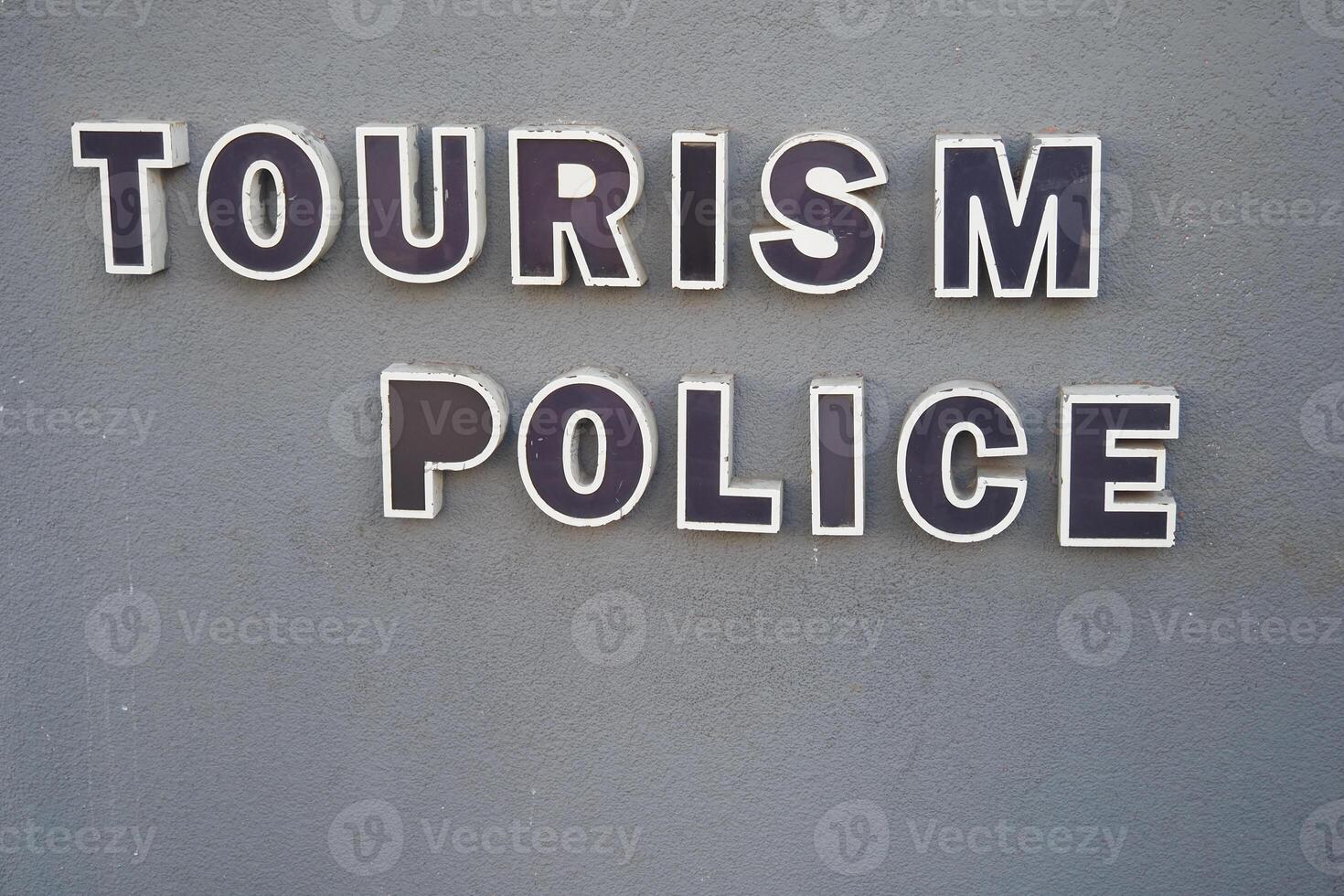 A visible sign for the Tourism Police prominently displayed on a building wall photo