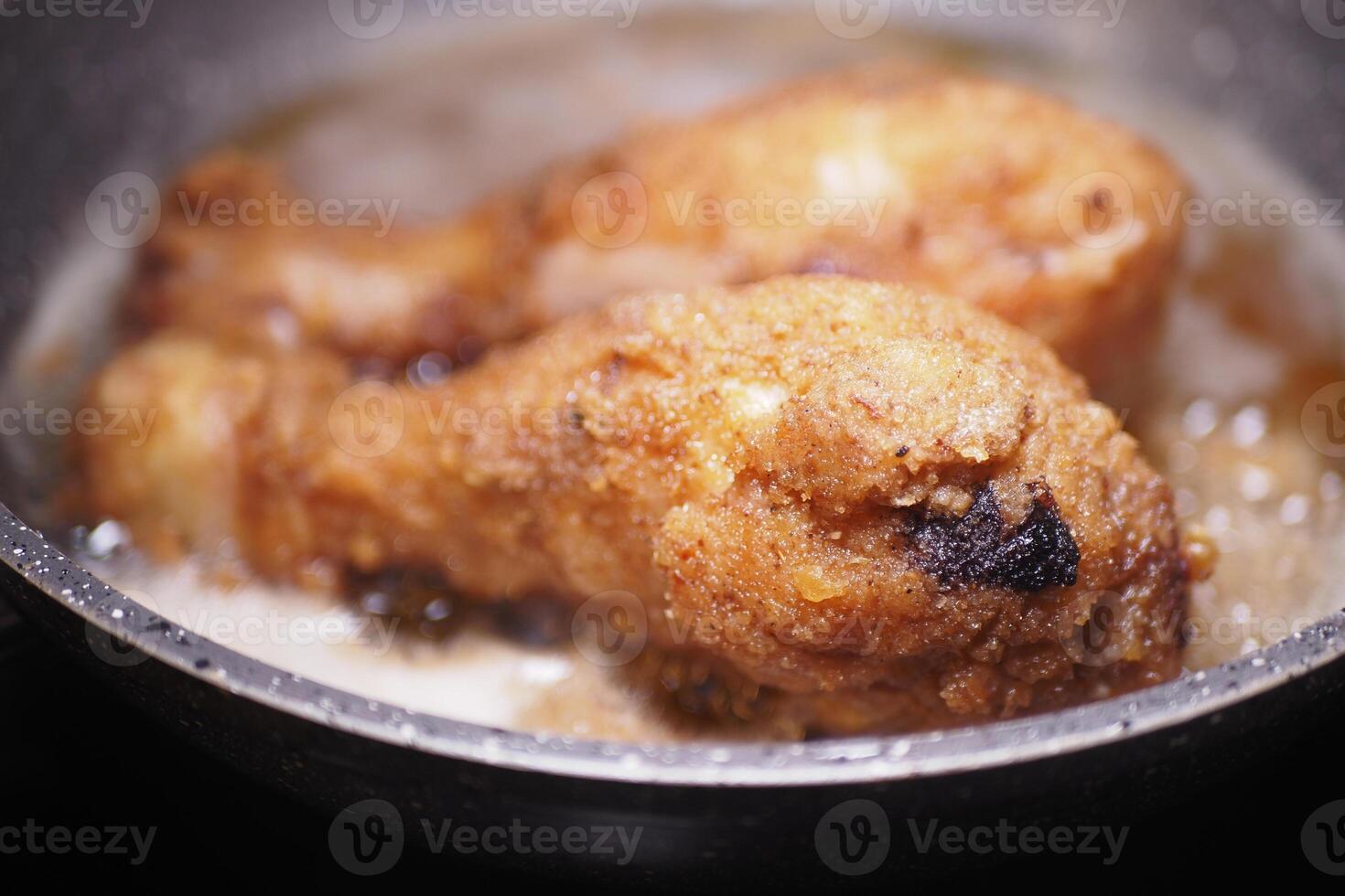 Delicious and Crispy Fried Chicken Drumsticks Cooked in a Pan photo