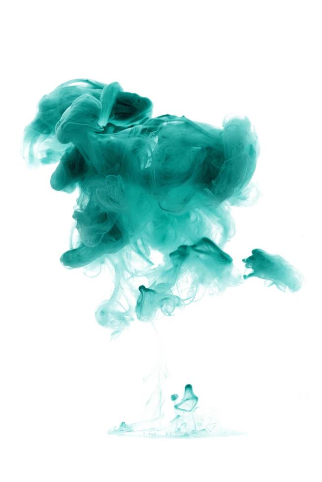 Green ink dropped in to water isolated white background. Abstract color dissolving in water photo