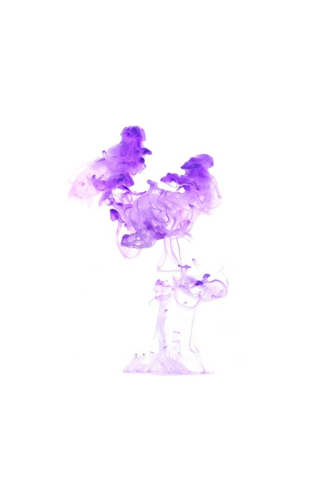 Purple ink dropped in to water isolated white background. Abstract color dissolving in water photo