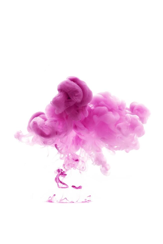 Pink ink dropped in to water isolated white background. Abstract color dissolving in water photo
