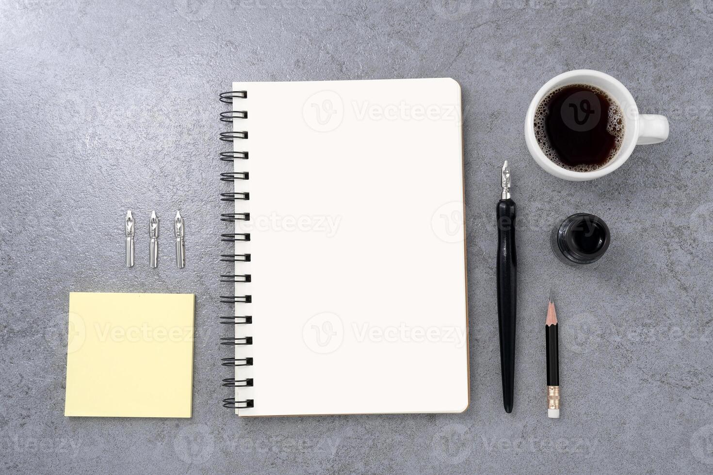 Blank book with dip pen on stone texture background. Writer workplace concept. photo