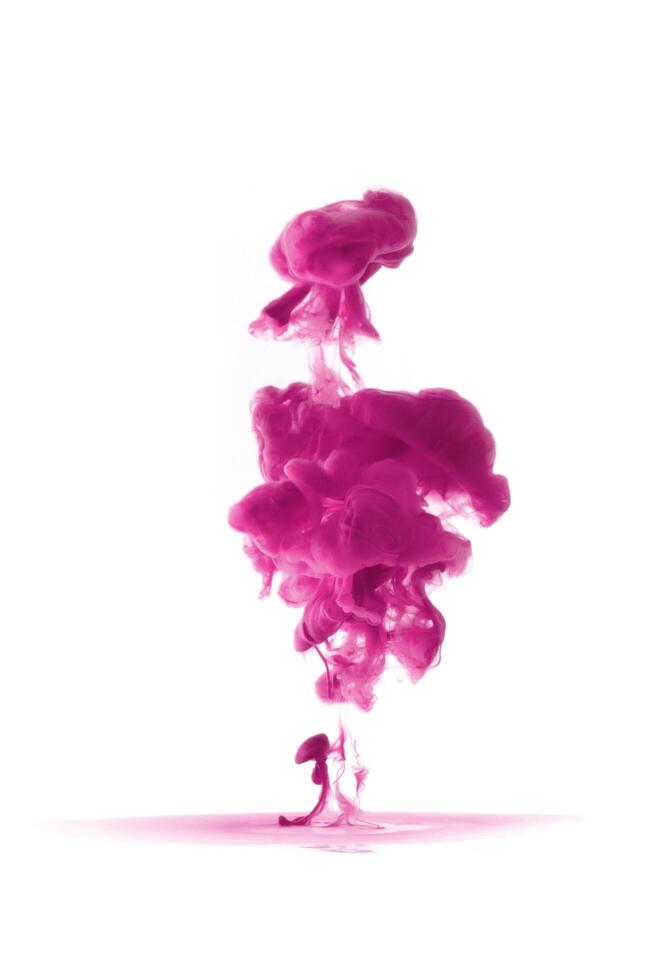 Pink ink dropped in to water isolated white background. Abstract color dissolving in water photo