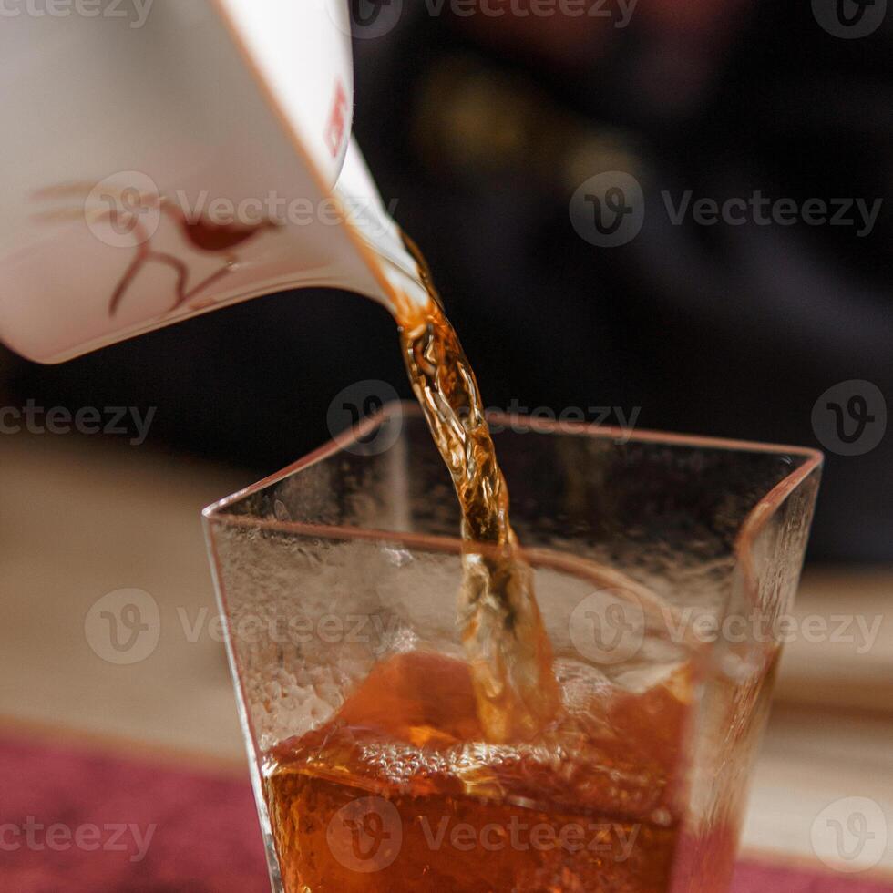 A Refreshing Pour of Iced Tea in a Glass Brings a Delightful Moment of Enjoyment photo