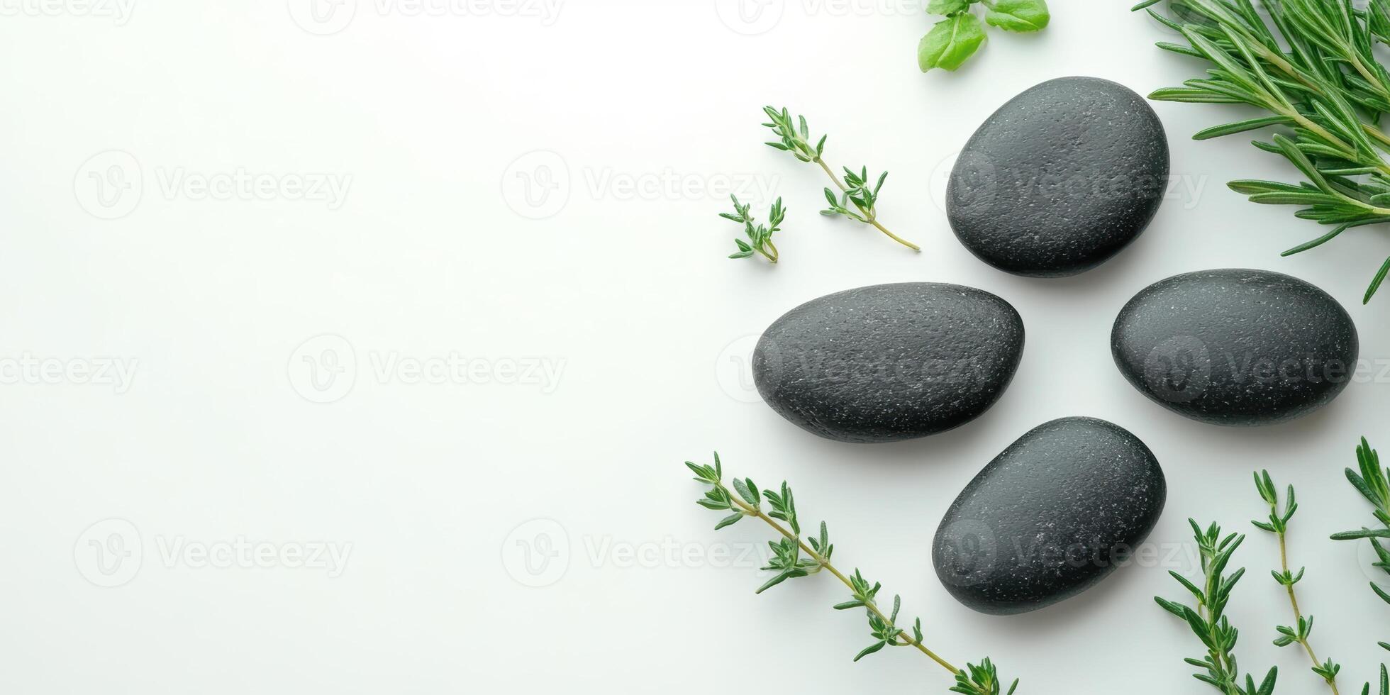 Black spa stones and fresh green herbs neatly arranged on a pristine white background photo