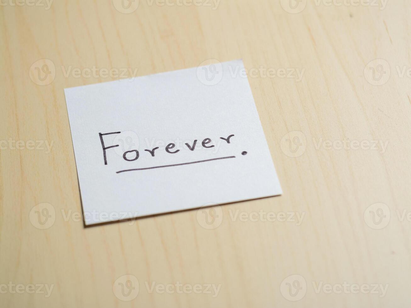 Inspirational handwritten 'forever' note in a minimalist home office environment photo