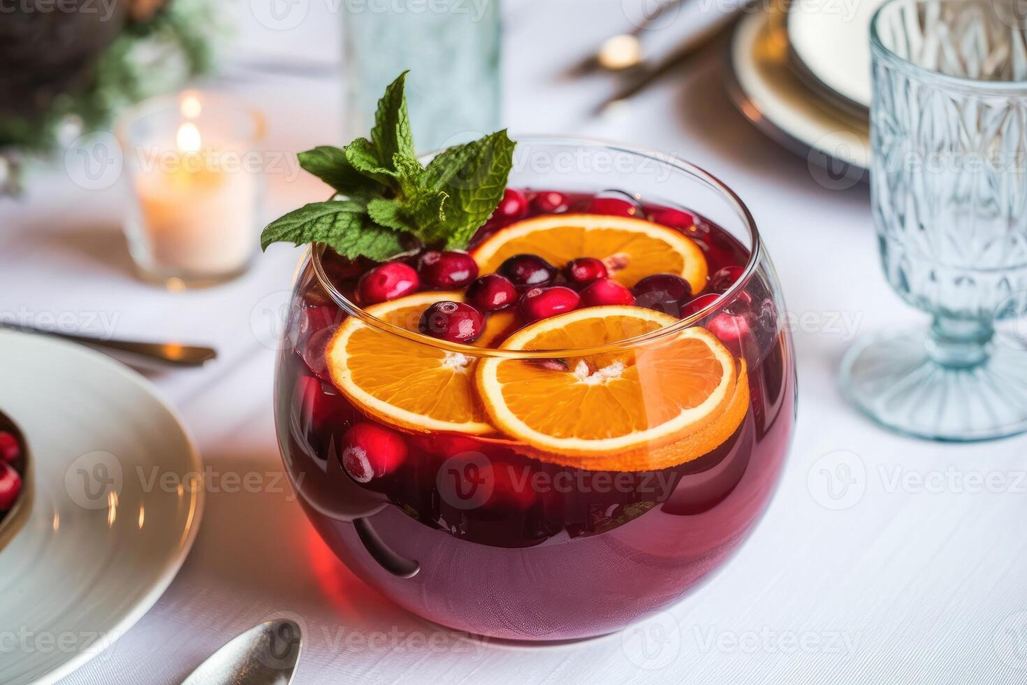 Christmas cranberry and orange punch with mint in glass bowl on festive table photo