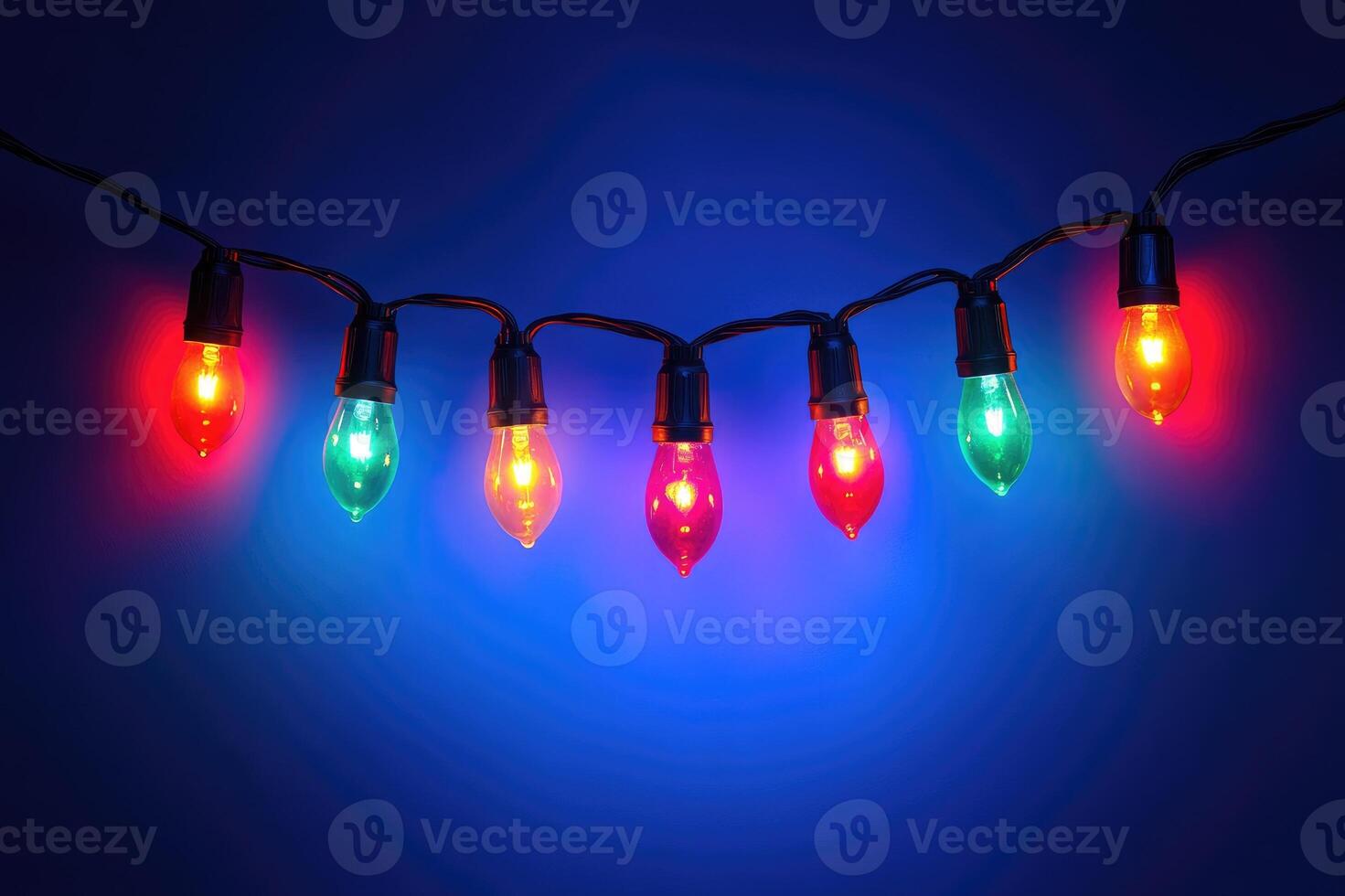 String of colorful christmas lights shining on blue background photo