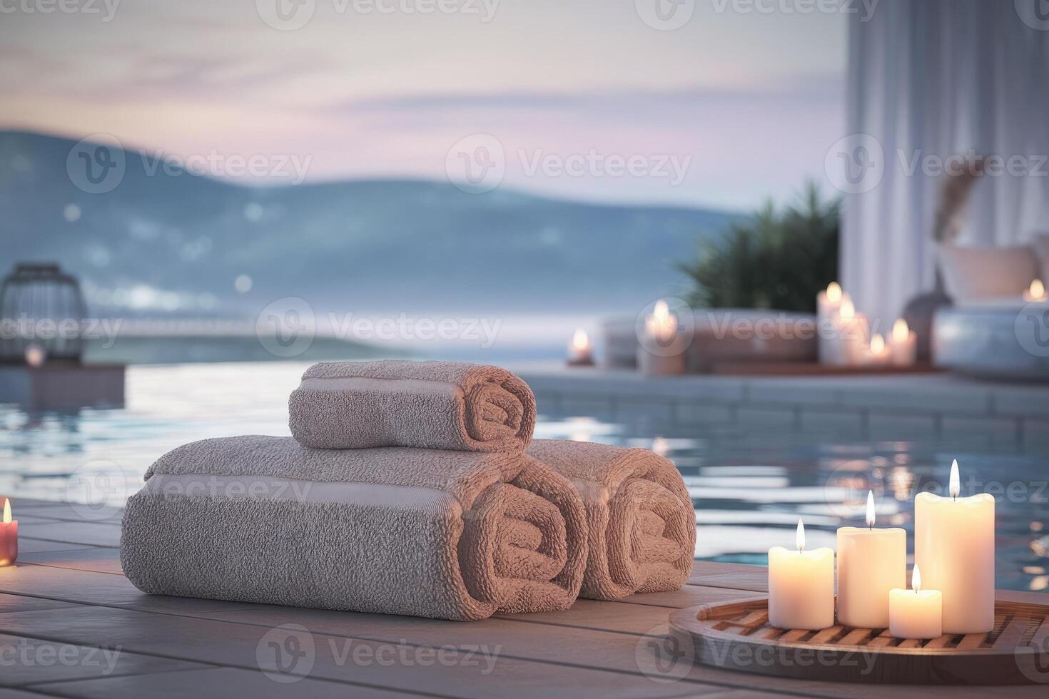 Rolled towels by infinity pool with burning candles at luxury resort photo