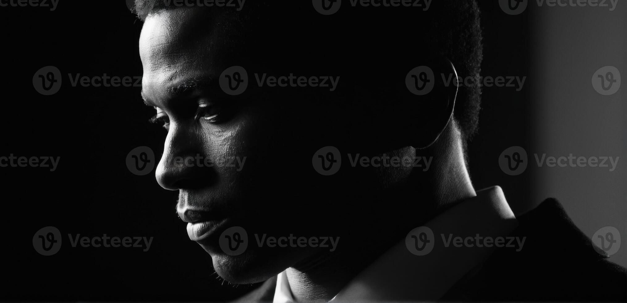 A black man in a suit and tie looking away photo