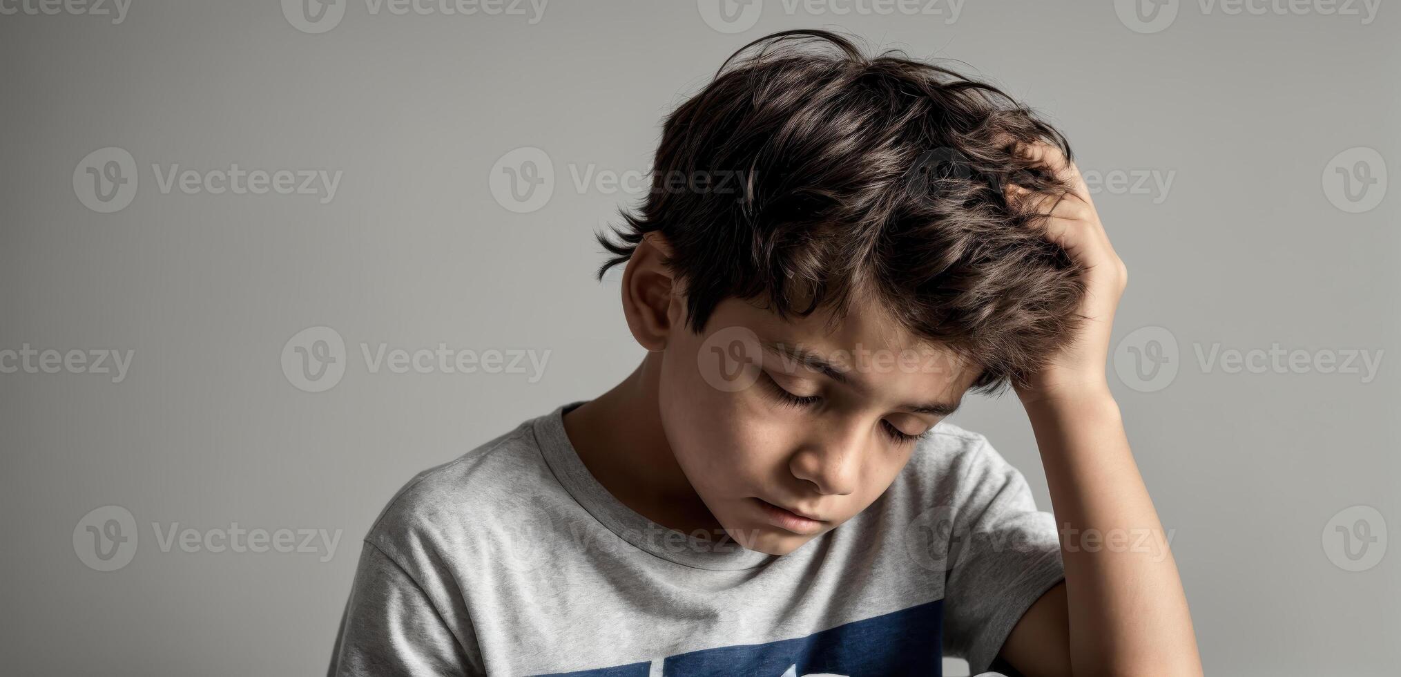 A boy is holding his head in his hands photo