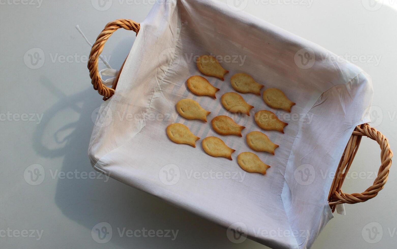 Domestic Fish Cookies In A Rows In Wicker Bread Basket On White Table photo