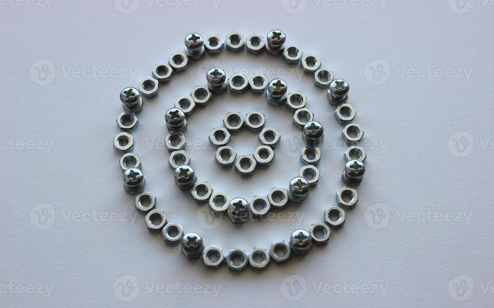 Mechanical Circle Pattern Of Metallic Color Nuts And Injected Bolts Isolated On Plastic Surface Top View photo