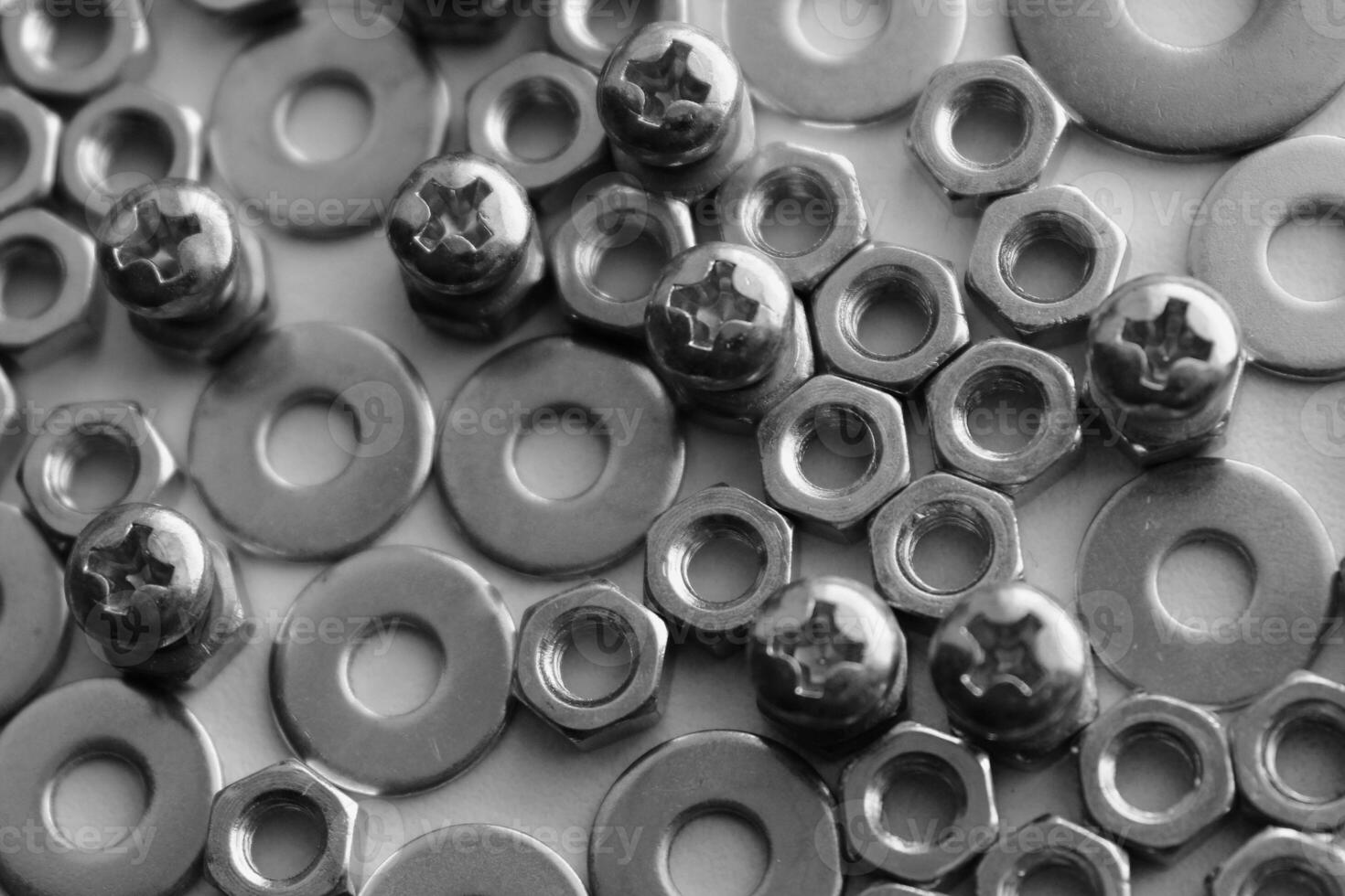 Black and white image of thread bolts injected in fixing nuts between flat washers. Macro shot stock photo for hardware products illustration