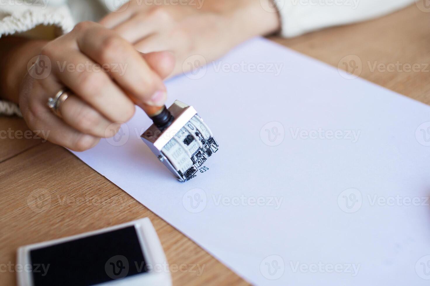 Hand Stamping Document on Desk Legal, Approval, Office Setting photo