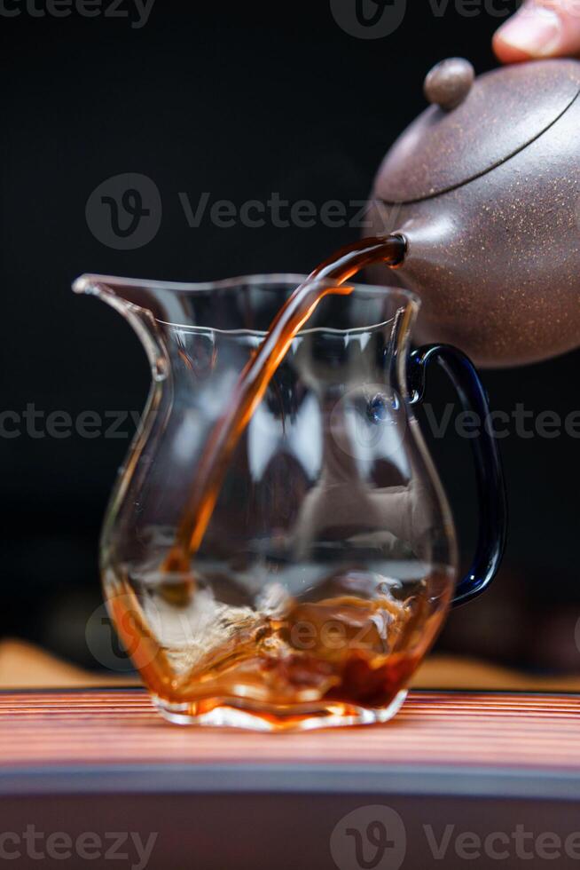 Experience the captivating and elegant tea pouring ritual conducted with a beautiful glass pitcher photo