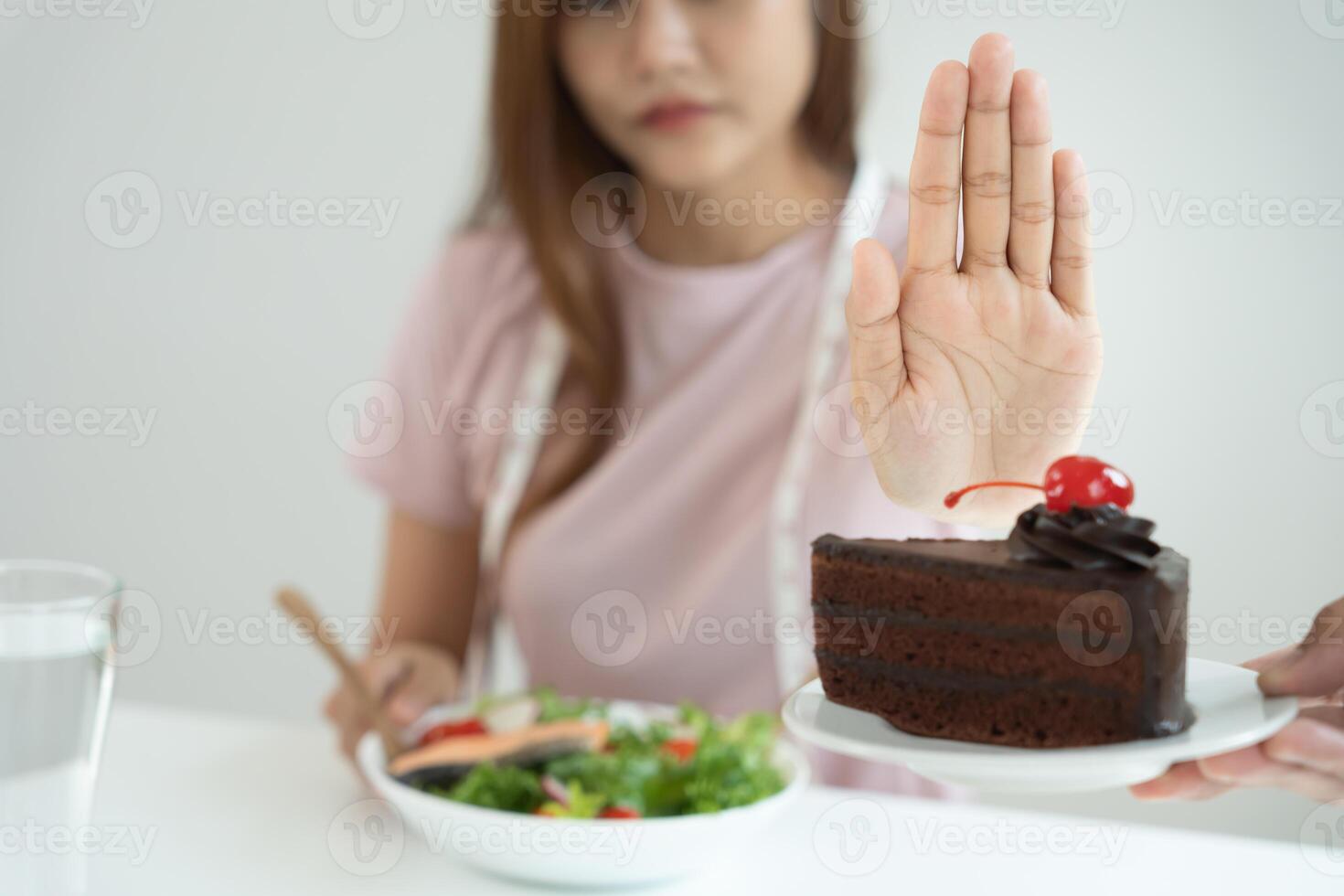 Beauty slim female body confuse chocolate cake. Woman in restaurant achieves weight loss goal for healthy life, crazy about thinness, thin waist, nutritionist. Diet, body shape. photo